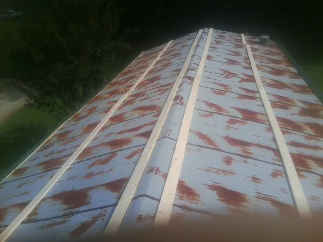 Rusted metal roof panels with new wood purlins before replacement — Storm Damage Roof Repair in Williamsburg by Roofing Brothers